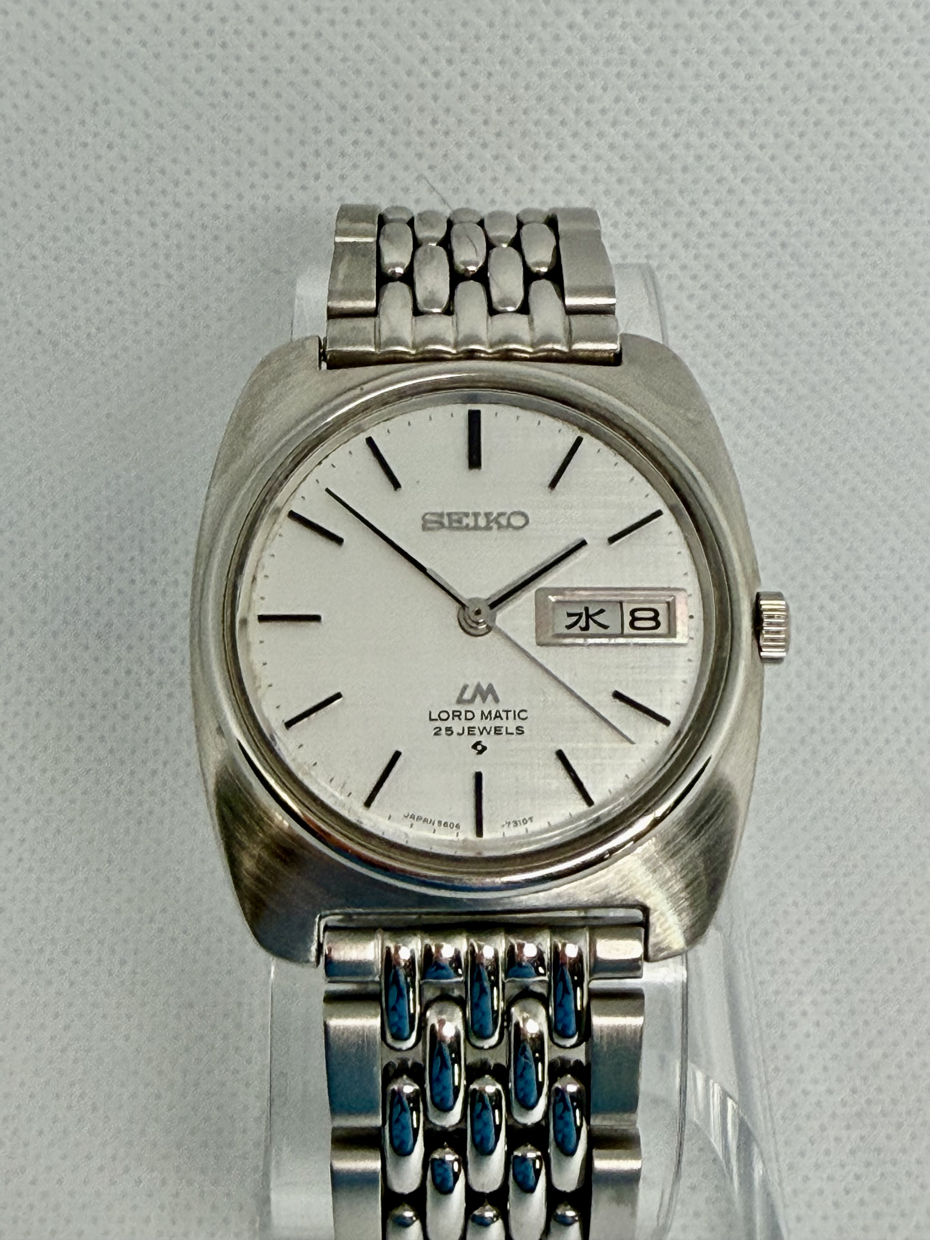1969 Seiko Lord Matic 5606-7130 with textured silver dial, bilingual Kanji day display, and stainless-steel beads-of-rice-style bracelet